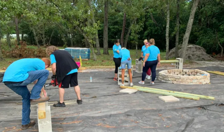 seven adults preparing new space for a gardena at the Hernando YMCA