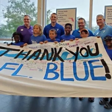 Young swimmers along with Y CEOs (L to R: YMCA of Greater St. Petersburg President/CEO David Jezek, Tampa Metropolitan Area YMCA President/CEO Matt Mitchell, Florida Blue’s Market President, West Florida Region David Pizzo, YMCA of the Suncoast President/CEO G. Scott Goyer) thank the Florida Blue Foundation for their generous donation to the Y’s Safety Around Water program. 