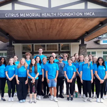 23 Teens in blue YOuth Leasership t-shirts in front of Citrus Memorial Health Foundation YMCA